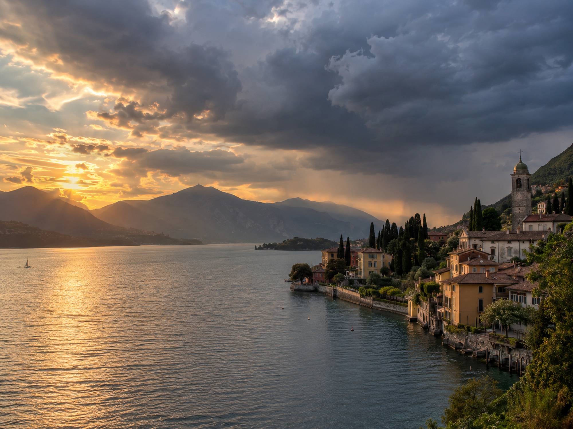 Borgo italiano sul lago con cielo drammatico tra sole e rovesci