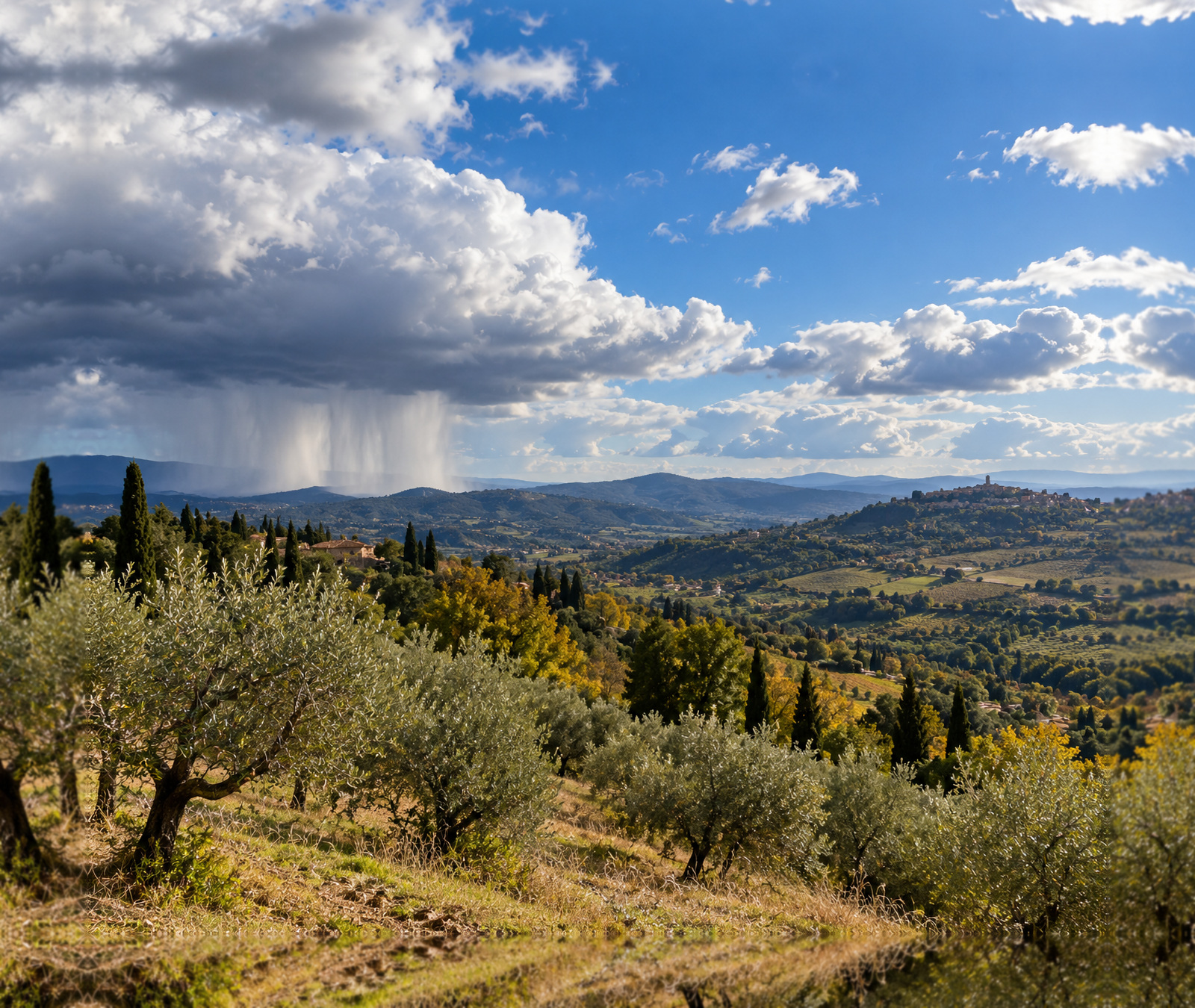 Paesaggio autunnale italiano con schiarite e nubi da rovescio in lontananza, immagine simbolica del tempo variabile di martedì.